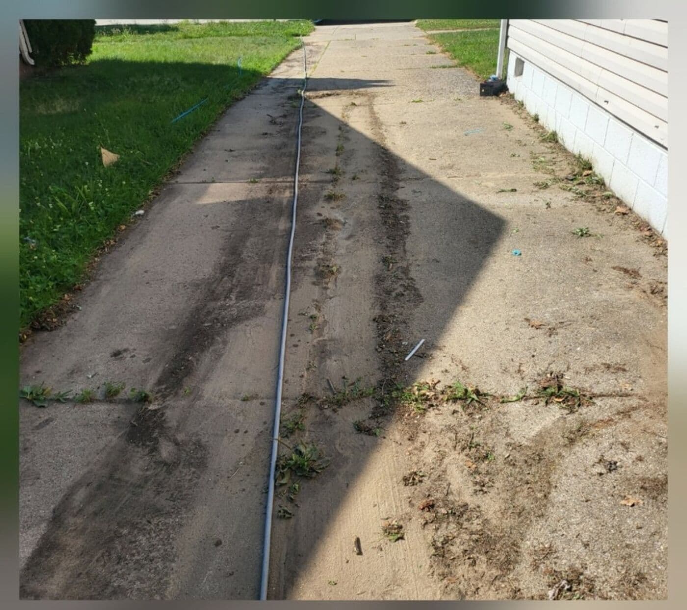 Concrete driveway and curb with heavy staining before pressure washing